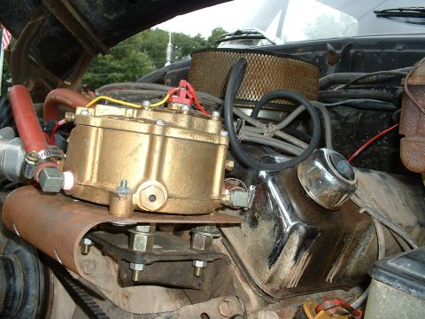 1978 Ford Bronco - Close-up of an engine bay showing a brass propane converter and air filter assembly.