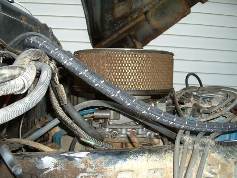 1978 Ford Bronco - Close-up view of a vehicle's engine bay, focusing on the carburetor and air filter assembly.