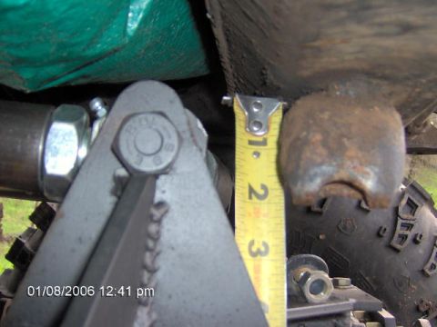 1979 Ford F-150 - A tape measure is used to gauge the size of a rusty suspension part.