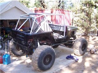 1986 Ford Bronco - This heavily modified off-road vehicle appears to be a custom build, possibly a buggy or heavily altered Jeep, with a prominent roll cage a…