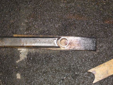 1990 Ford F-250 - Close-up of a metal bracket with a hole, possibly part of a vehicle's suspension or frame.