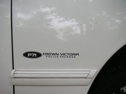 1997 Ford Crown Victoria - Close-up of a "P71 Crown Victoria Police Package" decal on a white vehicle door.