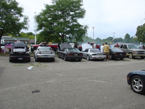 1986 Mazda RX-7 - A silver 1992 Mazda RX-7 is parked among other vehicles at an outdoor event.