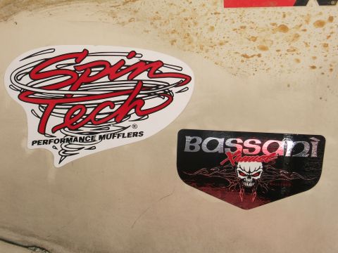1991 Ford Bronco - Two aftermarket exhaust brand stickers are visible on a vehicle's surface.