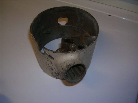 1975 Ford Ranchero - This is a metal steering column shroud, likely from an older vehicle, showing signs of wear and tear.