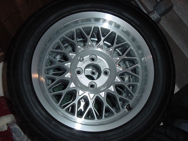 Close-up of a silver mesh wheel with a tire