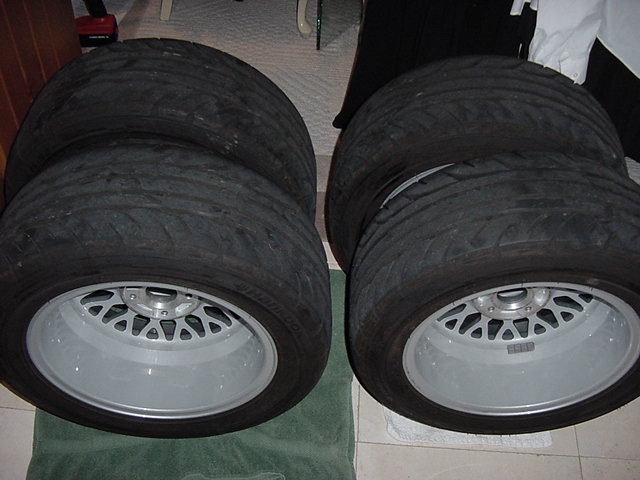four tires stacked on custom wheels