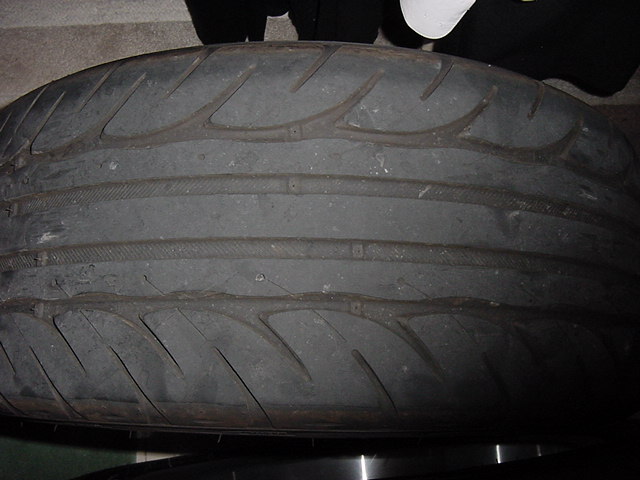 Worn tire tread with visible wear bars and Supermotors.net logo