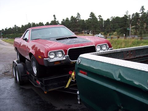 1972 Ford Ranchero - A red 1972 Ford Ranchero is loaded onto a trailer, ready for transport.