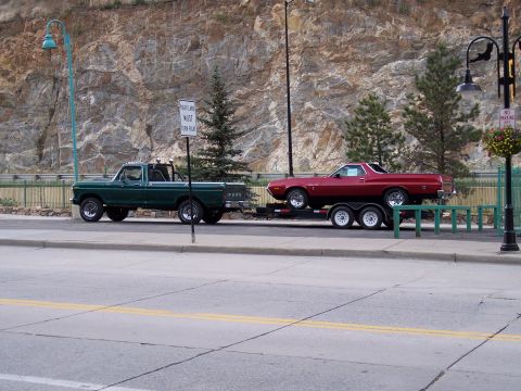1972 Ford Ranchero - A red 1972 Ford Ranchero is seen being towed by a green pickup truck.