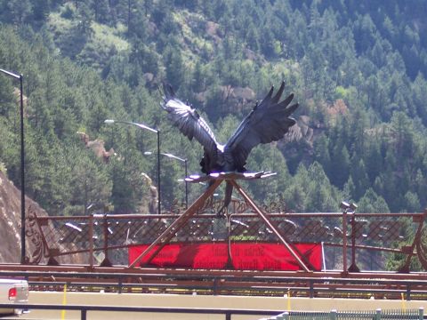 1972 Ford Ranchero - Eagle sculpture on a bridge with a red banner and mountainous backdrop.