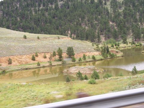 1972 Ford Ranchero - A tranquil scene of a pond reflecting the surrounding hills and dense pine forest.