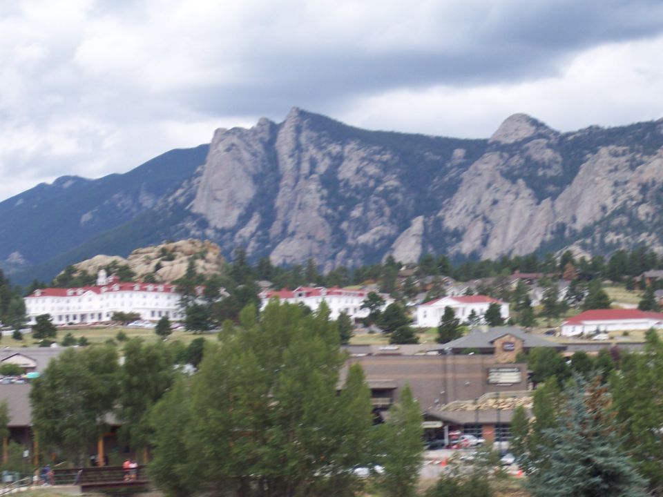 Mountain town with red-roofed buildings below rocky peaks