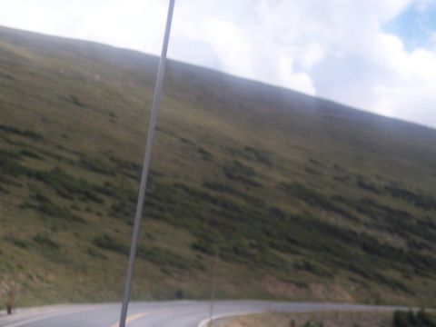 1972 Ford Ranchero - A winding road traverses a vast, green mountainside under a partly cloudy sky.