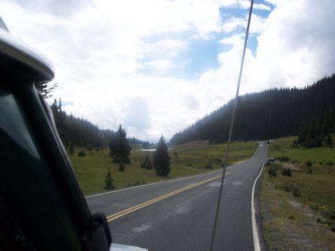 1972 Ford Ranchero - View from inside a green vehicle looking out at a scenic mountain road on a cloudy day.