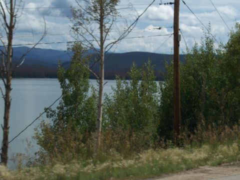 1972 Ford Ranchero - A scenic view of a lake and distant mountains framed by trees and utility poles under a cloudy sky.