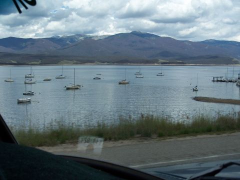 1972 Ford Ranchero - A calm lake dotted with sailboats, with a mountain range visible on the horizon.