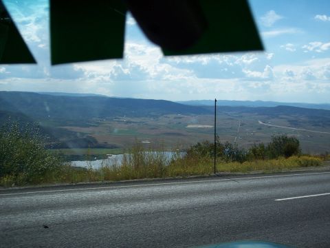 1972 Ford Ranchero - A wide view of a valley with a lake and distant mountains, seen from a moving vehicle.