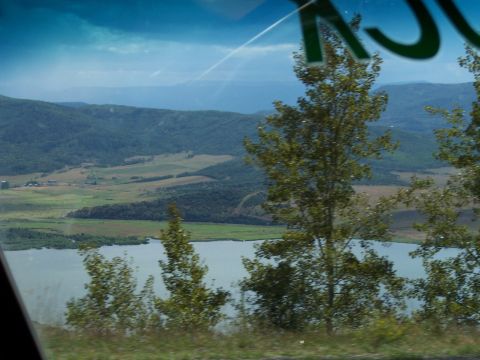 1972 Ford Ranchero - A scenic vista unfolds, showing a tranquil lake bordered by verdant hills under a dynamic sky.