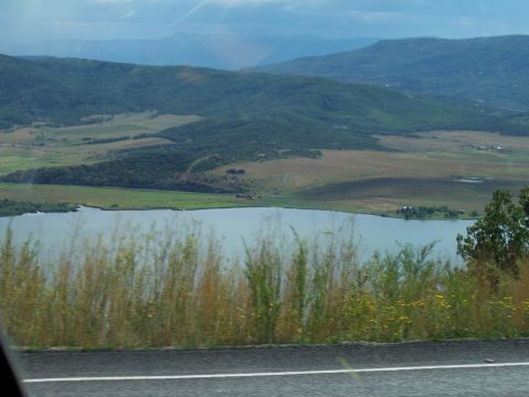 1972 Ford Ranchero - A wide view of a lake surrounded by hills and fields, with tall grass in the foreground.