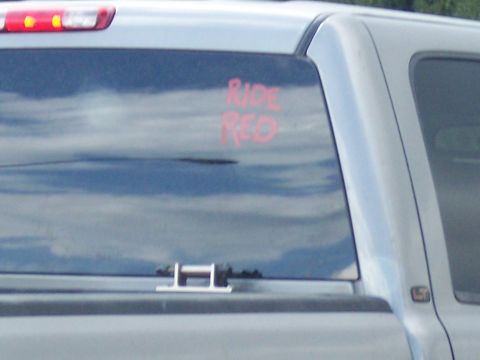 1972 Ford Ranchero - Rear window of a silver pickup truck displays red lettering reading 'RIDE RED'.