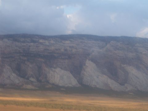 1972 Ford Ranchero - A vast mountain range dominates the landscape under a dramatic sky, with dry, golden grass covering the foreground.