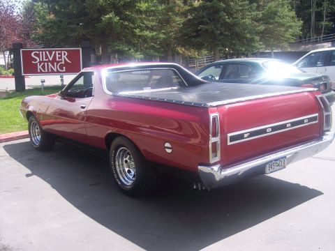 1972 Ford Ranchero - Rear view of a red 1972 Ford Ranchero pickup truck parked outdoors with a black tonneau cover.