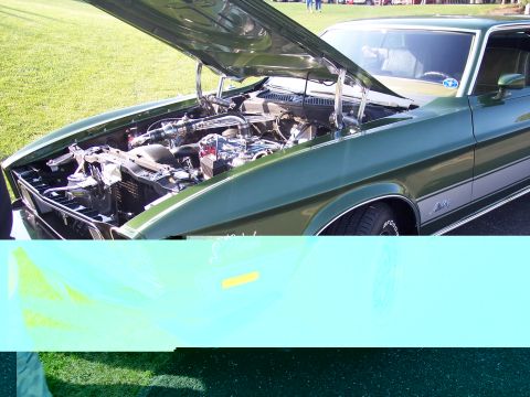 1972 Ford Ranchero - The hood is open on this green 1972 Ford Ranchero, revealing the engine bay.