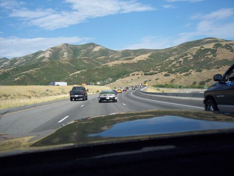 1972 Ford Ranchero - Traffic moves along a highway with rolling hills and a blue sky overhead.