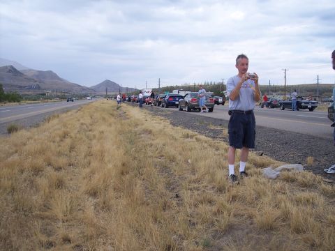 1972 Ford Ranchero - A group of cars are parked along the highway with people standing around them.