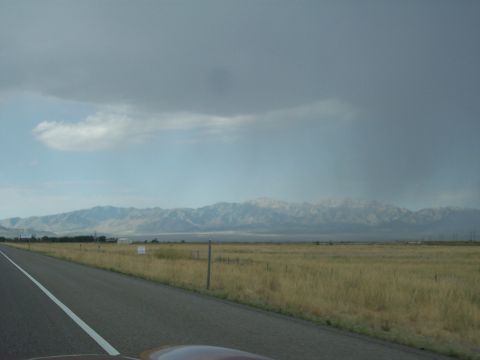 1972 Ford Ranchero - A vast landscape unfolds with a highway leading towards distant mountains under a dramatic sky.