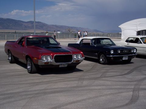 1972 Ford Ranchero - Two classic cars, a coupe utility and a convertible, are parked outdoors with mountains in the distance.