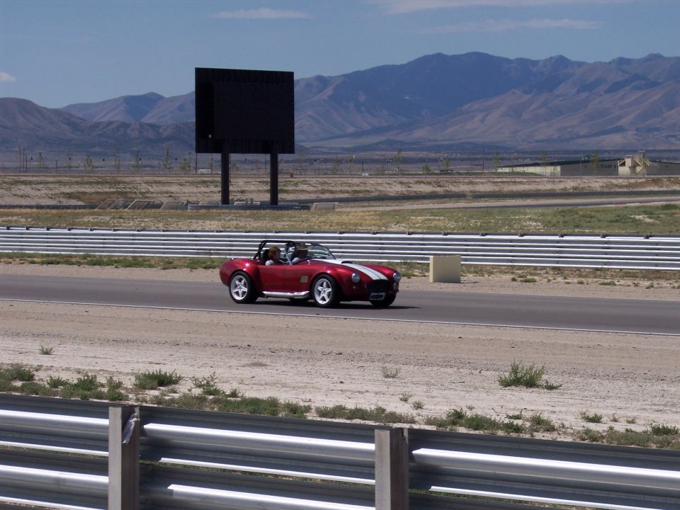 Red roadster with white stripe on desert racetrack