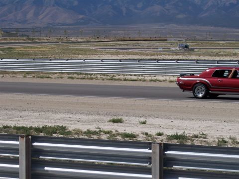 1972 Ford Ranchero - A red 1969 Mercury Cougar XR7 drives on a racetrack, with mountains in the background.