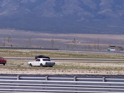 1972 Ford Ranchero - A white 1967 Ford Mustang coupe is on a racetrack, with other vehicles visible in the background.