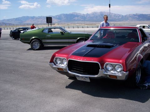 1972 Ford Ranchero - Two classic American muscle cars parked outdoors on a sunny day with mountains in the distance.