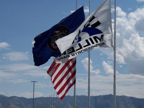 1972 Ford Ranchero - Flags fly against a cloudy blue sky, with mountains in the background.