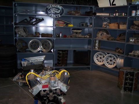 1972 Ford Ranchero - Shelving units display various Ford parts, including exhaust manifolds and wheels, with an engine in the foreground.