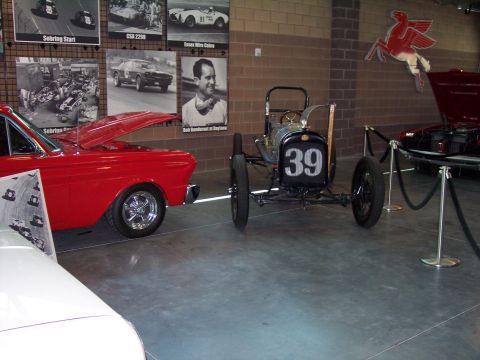 1972 Ford Ranchero - A vintage race car numbered 39 is displayed next to a red car with its hood open.
