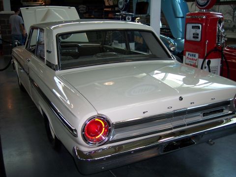 1972 Ford Ranchero - Rear view of a white 1963 Ford Falcon sedan with its hood open.