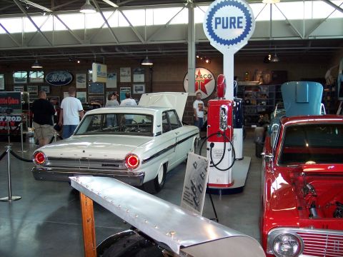 1972 Ford Ranchero - A classic Ford sedan is displayed indoors with vintage gas pumps and other memorabilia.