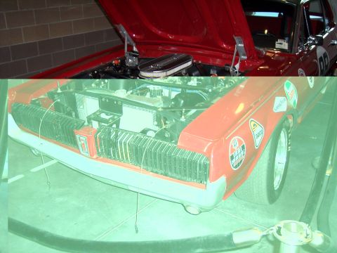1972 Ford Ranchero - A red car's engine bay and front grille are visible with the hood up, adorned with racing decals.