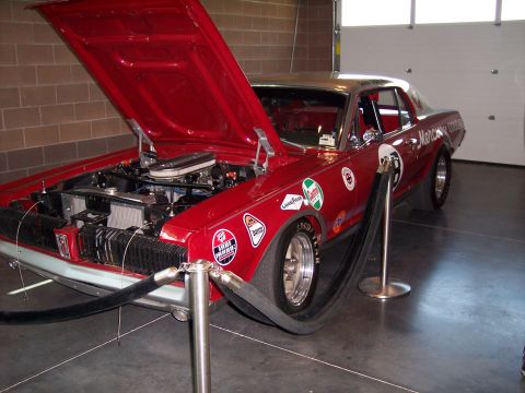 1972 Ford Ranchero - A red race car is displayed indoors with its hood up, revealing the engine compartment.