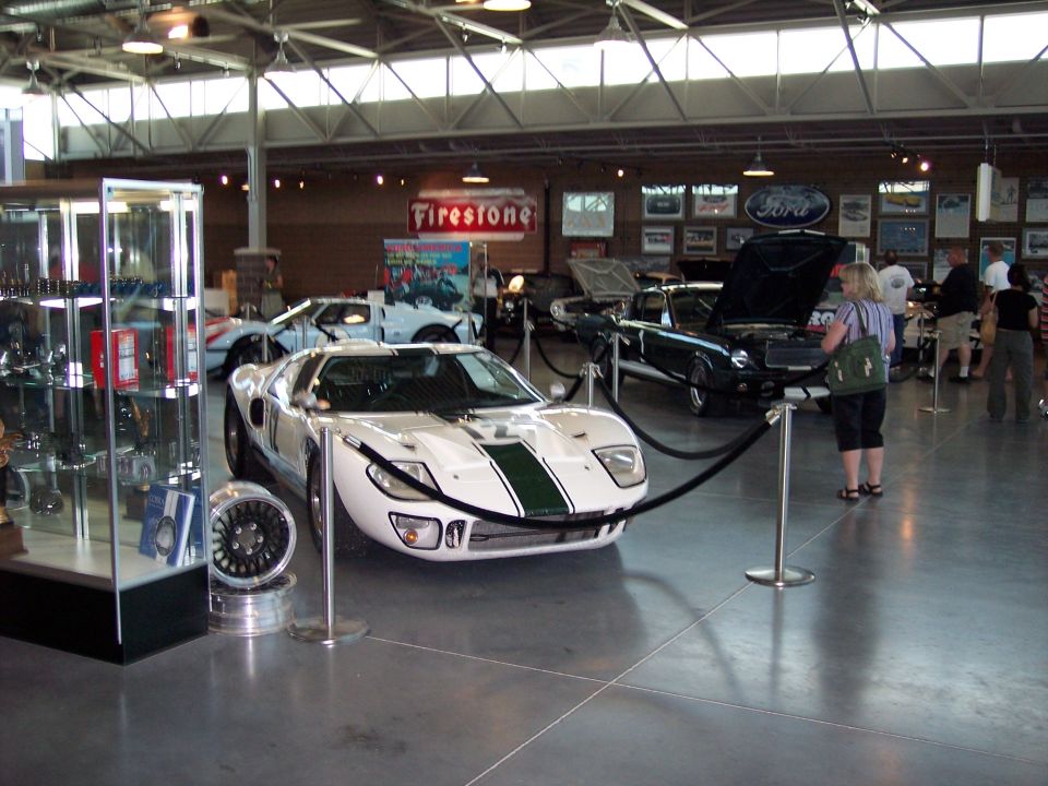 White GT40-style coupe with green stripes displayed in a car museum