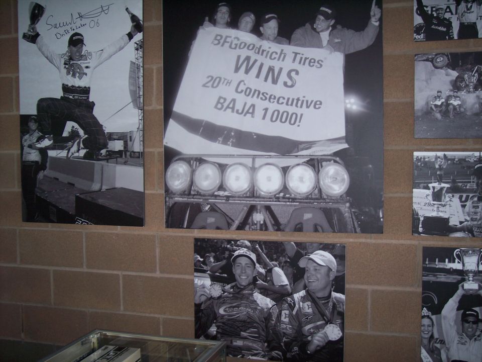 Black-and-white racing photo display with BFGoodrich Baja 1000 winning banner on brick wall