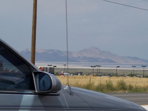 1972 Ford Ranchero - A view of a silver car's side mirror and hood against a backdrop of distant mountains and a sparse, dry landscape.