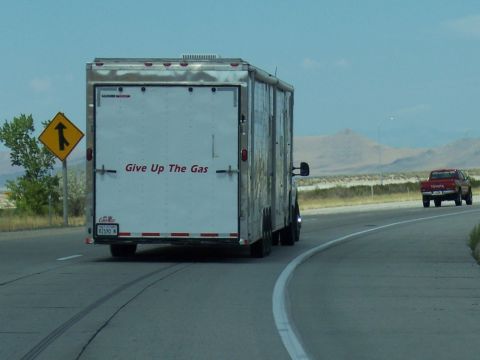 1972 Ford Ranchero - A trailer with text is seen on the highway, with a red pickup truck driving ahead.