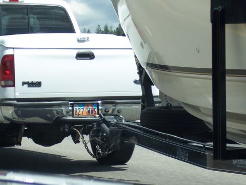 1972 Ford Ranchero - A white pickup truck is seen from the rear, towing a boat on a trailer. The Utah license plate reads 827 HNS.