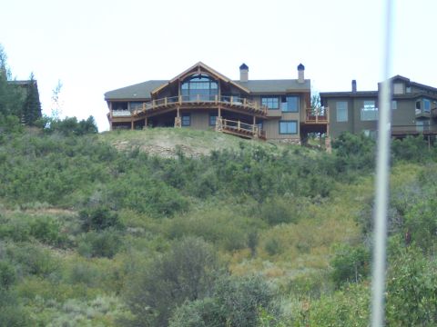 1972 Ford Ranchero - Houses are situated on a hill with dense vegetation in the foreground and background.