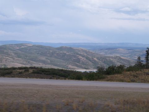 1972 Ford Ranchero - A scenic view of rolling hills and a road under a cloudy sky, with a hint of water in the distance.